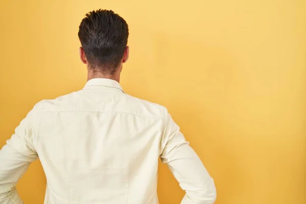Young Hispanic Man Standing Yellow Background Standing Backwards Looking Away — Stockfoto