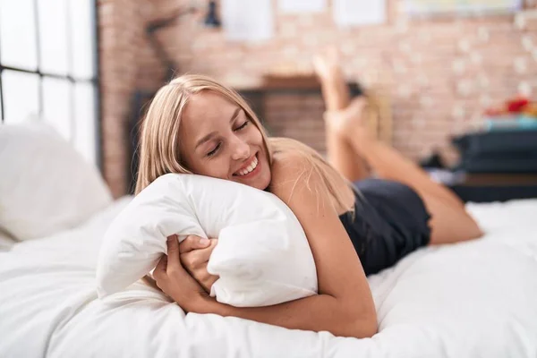 Young Blonde Woman Hugging Pillow Lying Bed Bedroom — Stockfoto