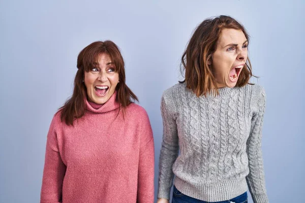 Mother Daughter Standing Blue Background Angry Mad Screaming Frustrated Furious — Stock Photo, Image