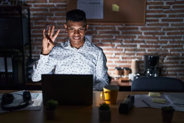 Młody Hiszpan Pracujący Biurze Nocy Pokazuje Wskazuje Palcami Numer Cztery — Zdjęcie stockowe