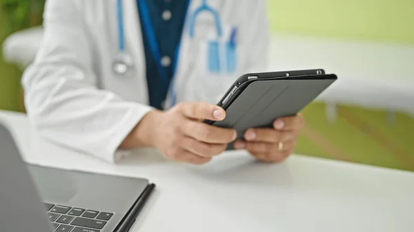 Joven Médico Hispano Usando Touchpad Sentado Clínica —  Fotos de Stock