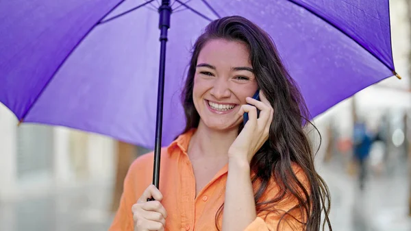 Young Beautiful Hispanic Woman Holding Umbrella Talking Smartphone Street — Stock Photo, Image