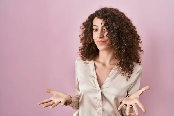 Pembe Arka Planda Duran Kıvırcık Saçlı Spanyol Kadın Güler Yüzlü — Stok fotoğraf