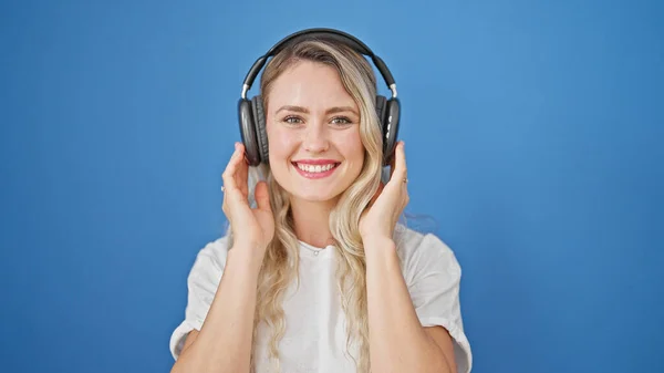 Mujer Rubia Joven Sonriendo Confiada Usando Auriculares Sobre Fondo Azul — Foto de Stock
