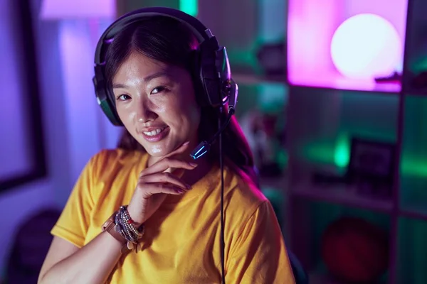 中国女人带着自信的笑容在游戏室使用耳机 — 图库照片