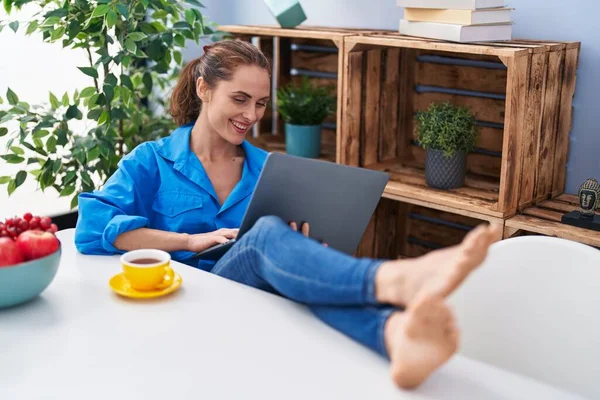 Junge Frau Benutzt Laptop Und Trinkt Kaffee Hause Auf Sofa — Stockfoto