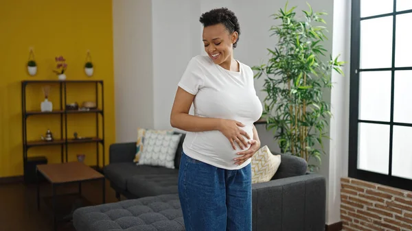 Junge Schwangere Frau Lächelt Selbstbewusst Und Berührt Bauch Hause — Stockfoto