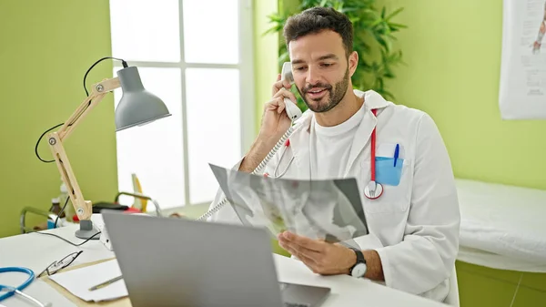 Молодий Іспаномовний Лікар Розмовляє Телефону Тримаючи Рентген Клініці — стокове фото