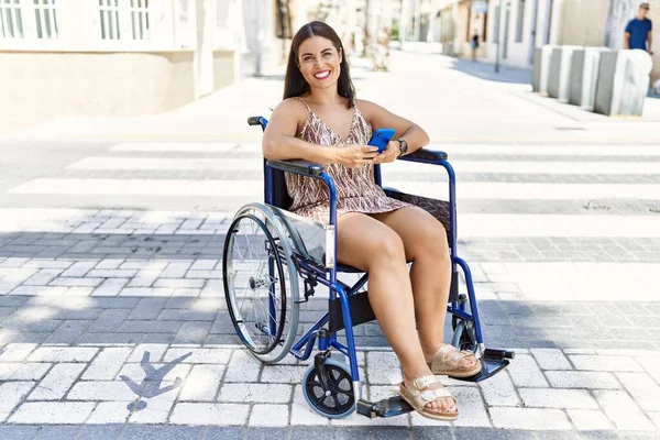 Junge Schöne Hispanische Frau Sitzt Mit Smartphone Rollstuhl Auf Der — Stockfoto