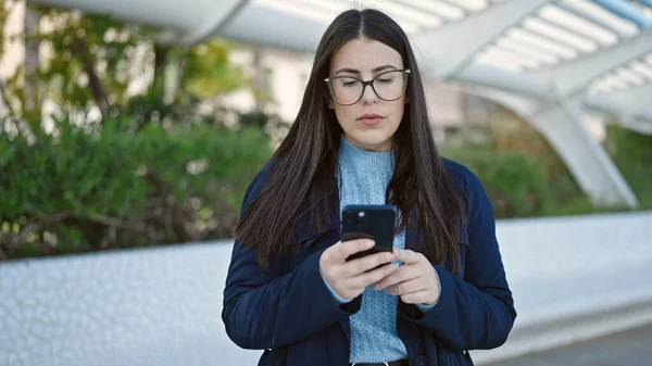 Mulher Hispânica Jovem Com Expressão Séria Usando Smartphone Parque — Fotografia de Stock