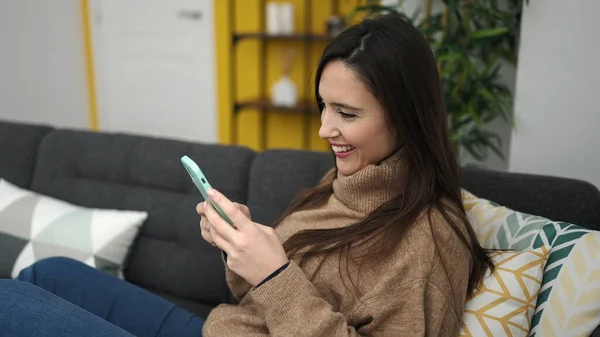 Krásná Hispánská Žena Pomocí Smartphone Sedí Pohovce Doma — Stock fotografie