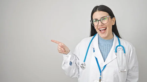 Joven Doctora Hispana Sonriendo Confiada Señalando Lado Sobre Fondo Blanco — Foto de Stock