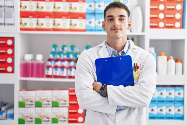 Jovem Hispânico Homem Farmacêutico Segurando Prancheta Farmácia — Fotografia de Stock