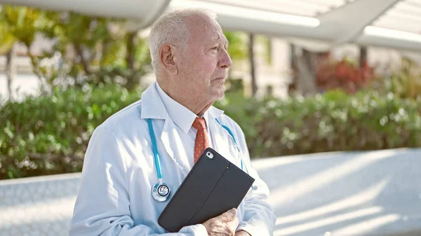 Starszy Siwowłosy Lekarz Stojący Poważnym Wyrazem Twarzy Trzymający Touchpad Parku — Zdjęcie stockowe