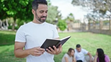 Bir grup öğrenci parkta kitap okuyor.