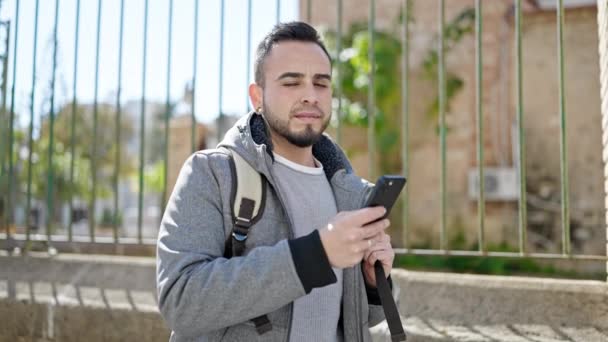 Ισπανόφωνος Άνθρωπος Χρησιμοποιώντας Smartphone Χαμογελώντας Στο Δρόμο — Αρχείο Βίντεο