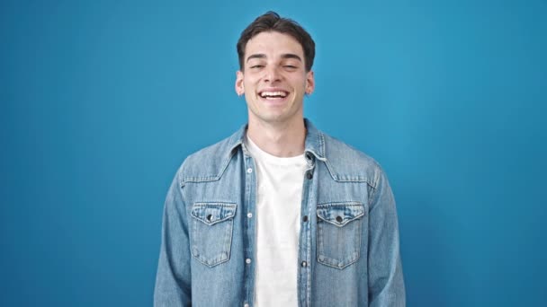 年轻的惊慌失措的男人面带微笑 自信地站在孤独的蓝色背景之上 — 图库视频影像