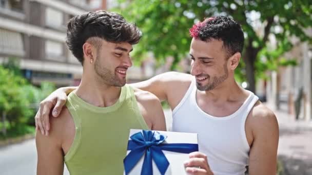Dos Hombres Pareja Sonriendo Confidente Sorpresa Con Regalo Cumpleaños Calle — Vídeo de stock