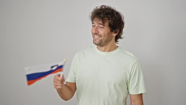 Jovem Hispânico Sorrindo Confiante Segurando Bandeira Eslovena Sobre Fundo Branco — Vídeo de Stock
