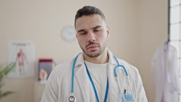 Jeune Homme Hispanique Médecin Debout Avec Une Expression Sérieuse Clinique — Video
