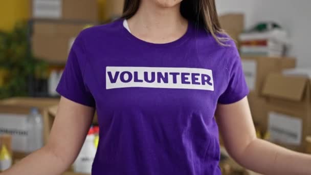 Jovem Bela Mulher Hispânica Apontando Para Uniforme Voluntário Centro Caridade — Vídeo de Stock