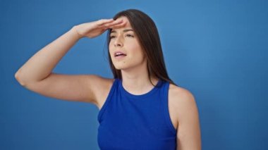 Genç, güzel, İspanyol bir kadın arıyor. Mavi arka planda güzel bir jest arıyor.