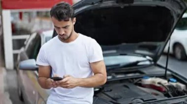 Genç İspanyol adam araba arızası için sigorta şirketine mesaj atıyor.
