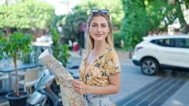 Genç sarışın kadın turist gülümsüyor. Kendine güvenen şehir haritası.