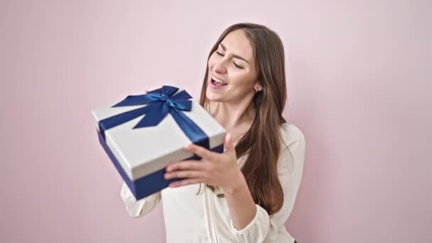 Jong Mooi Latino Vrouw Glimlachen Zelfverzekerd Holding Gift Geïsoleerde Roze — Stockvideo