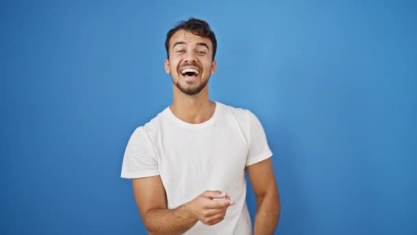Νεαρός Ισπανόφωνος Που Γελάει Πολύ Πάνω Απομονωμένο Μπλε Φόντο — Αρχείο Βίντεο