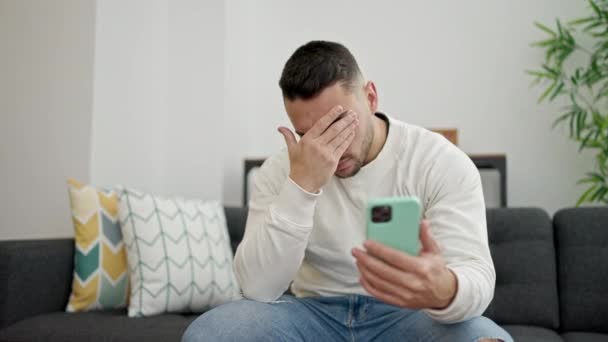 Hombre Hispano Joven Estresado Sentado Sofá Usando Smartphone Casa — Vídeos de Stock