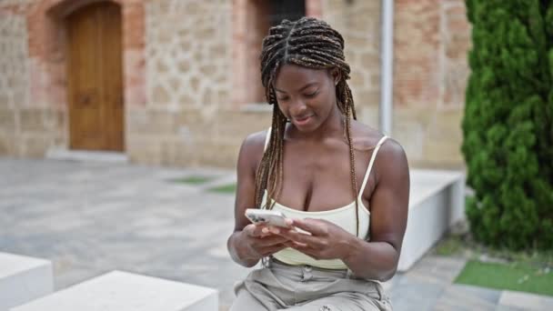 Femme Afro Américaine Utilisant Smartphone Assis Sur Banc Rue — Video