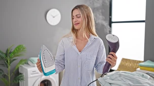 Junge Blonde Frau Lächelt Selbstbewusst Und Wählt Bügeleisen Der Waschküche — Stockvideo
