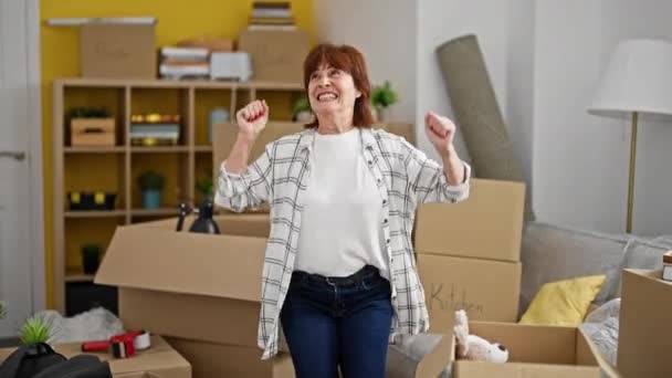 Μεσήλικας Γυναίκα Χαμογελά Αυτοπεποίθηση Στέκεται Χειρονομία Νικητής Στο Νέο Σπίτι — Αρχείο Βίντεο