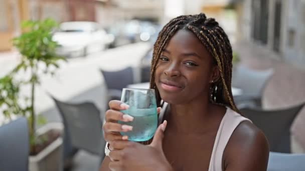 Mujer Afroamericana Sosteniendo Vaso Agua Sentada Mesa Terraza Cafetería — Vídeos de Stock