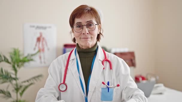 Starší Hispánská Žena Lékař Úsměvem Dělá Srdeční Gesto Rukama Klinice — Stock video