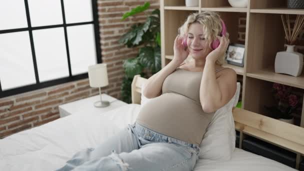 Mujer Embarazada Joven Escuchando Música Poniendo Auriculares Vientre Dormitorio — Vídeos de Stock