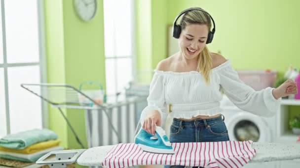 Genç Sarışın Kadın Müzik Dinliyor Çamaşırhanede Giysileri Ütülüyor Dans Ediyor — Stok video