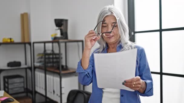 中年白发苍苍的女商人戴着眼镜在办公室看文件 — 图库视频影像