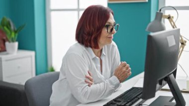Orta yaşlı kadın emlakçı elinde ofiste gülümseyen yeni evin anahtarları var.