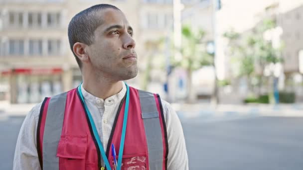 Jonge Spaanse Man Vrijwilliger Draagt Vest Ziet Serieus Uit Straat — Stockvideo