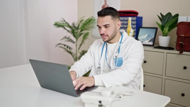 Young Hispanic Man Doctor Using Laptop Working Clinic — Stok video