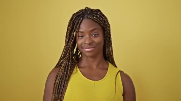Africano Americano Mulher Sorrindo Confiante Sobre Isolado Fundo Amarelo — Vídeo de Stock