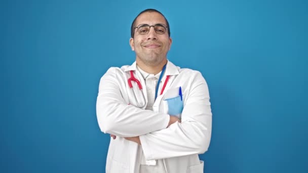 Junger Hispanischer Arzt Lächelt Selbstbewusst Mit Verschränkten Armen Vor Isoliertem — Stockvideo