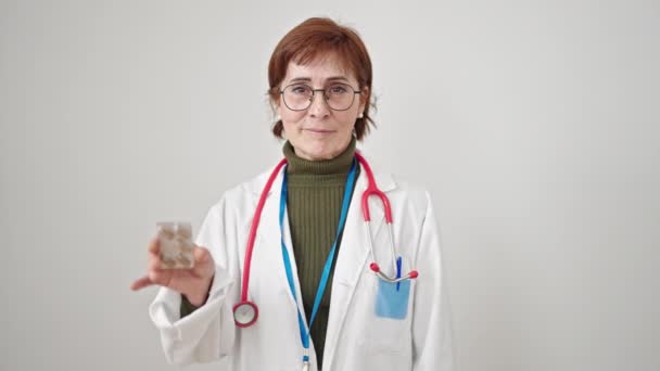 Ältere Hispanische Ärztin Hält Pillen Über Isoliertem Weißen Hintergrund — Stockvideo