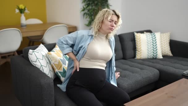 Młoda Kobieta Ciąży Cierpiąca Bóle Pleców Siedząca Kanapie Domu — Wideo stockowe