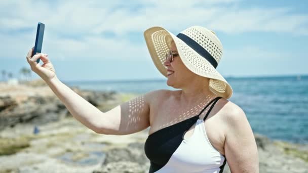 中年白发女游客穿着泳衣在海滩用智能手机自拍 — 图库视频影像