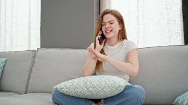 Junge Blonde Frau Spricht Auf Smartphone Sitzt Auf Sofa Und — Stockvideo