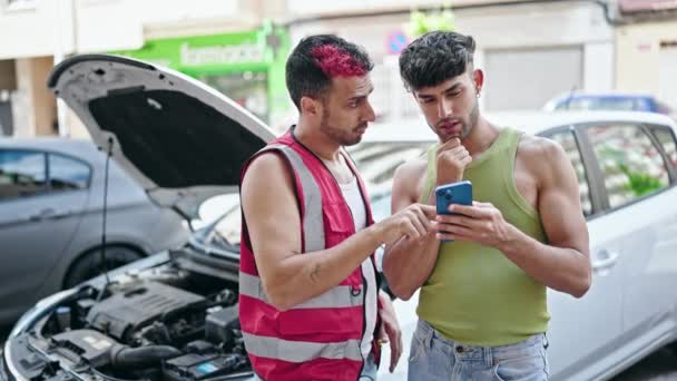 Twee Mannen Met Smartphone Met Verzekering Voor Autopech Straat — Stockvideo