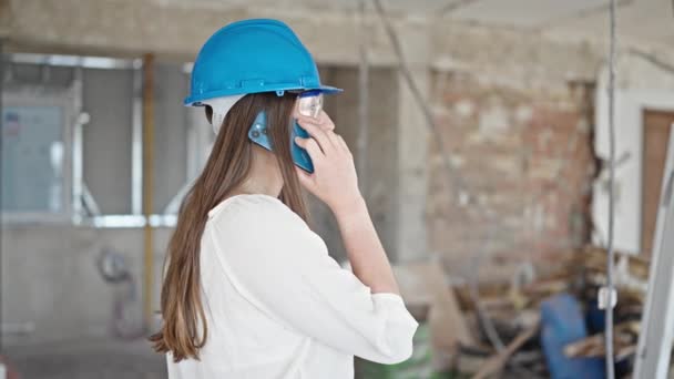 年轻美丽的惊慌失措的女建筑商在建筑工地用智能手机交谈 — 图库视频影像
